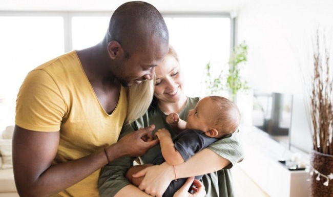 a man and woman holding a baby