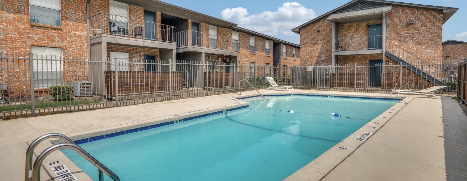 a swimming pool in front of a brick building